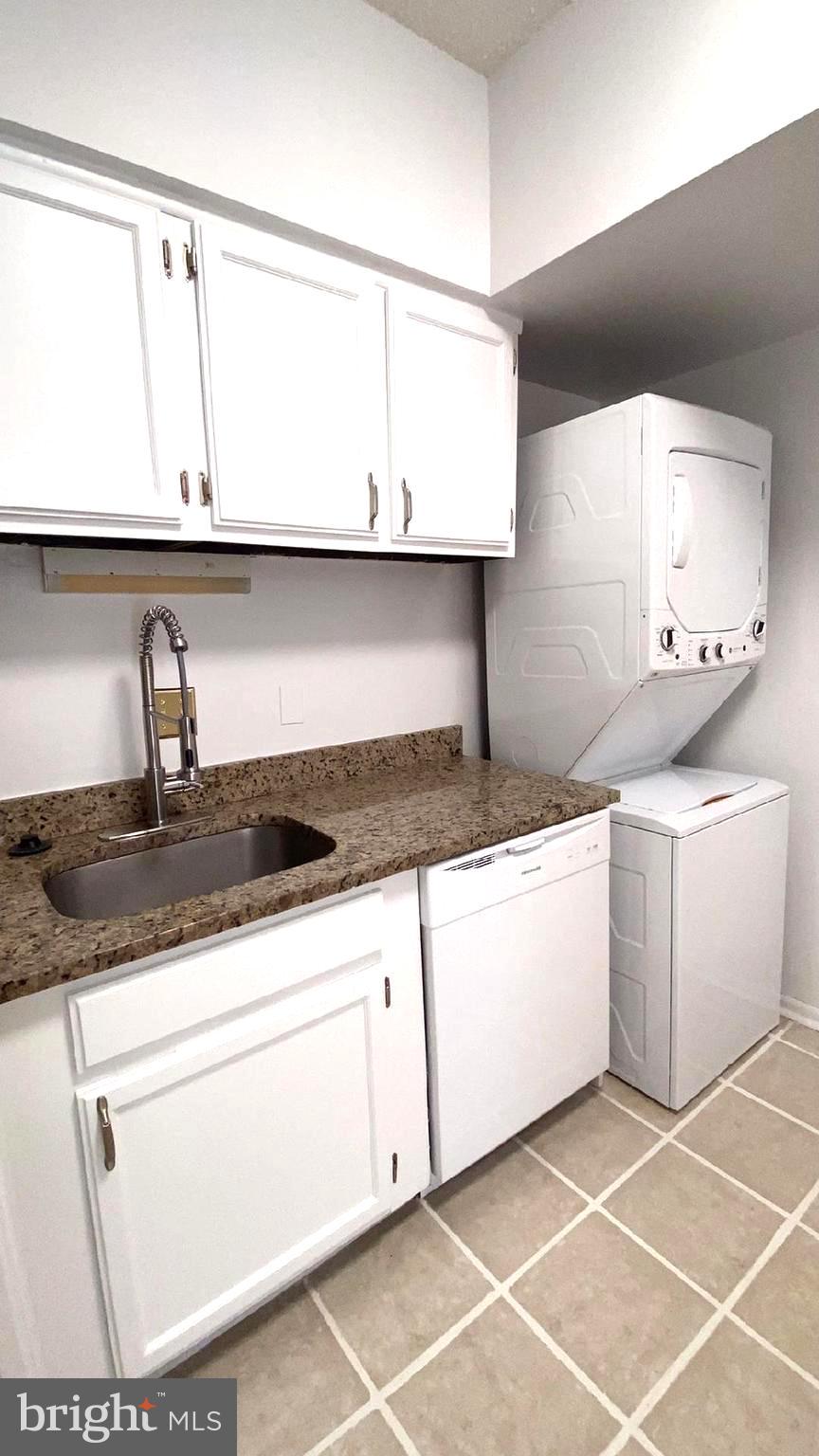 11839 Shire Court, Unit 2C Reston, VA 20191 - Photo 57 of 60 a kitchen with granite countertop white cabinets and white appliances