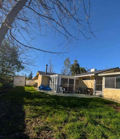 a view of a house with backyard and sitting area