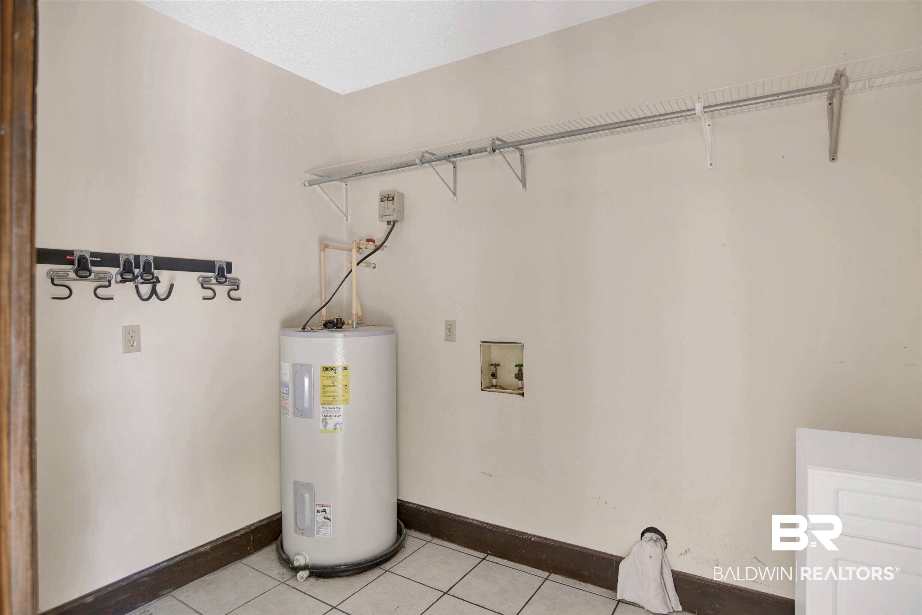 30888 Cemetery Road Daphne, AL 36527 - Photo 36 of 36 Dedicated utility area featuring white tile flooring, a water heater, washer hookups, and integrated wire shelving