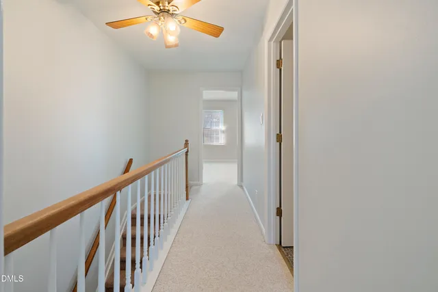 a view of a hallway with a chandelier fan
