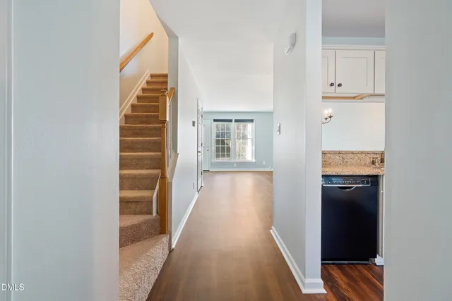 a view of a hallway with wooden floor and staircase