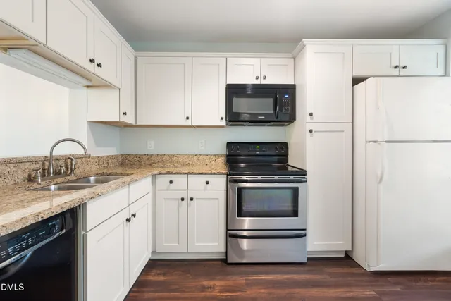 a kitchen with white cabinets and white appliances