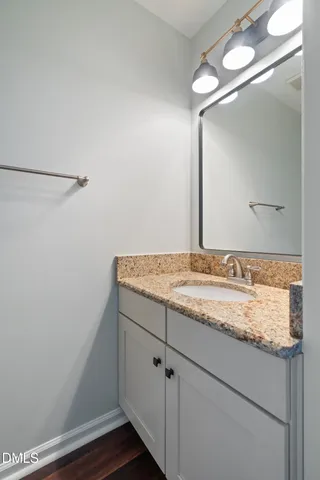 a bathroom with a granite countertop sink and a mirror