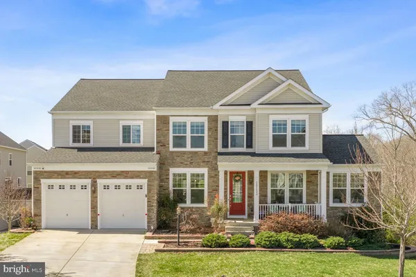 a large kitchen with granite countertop a dining table chairs wooden cabinets and stainless steel appliances