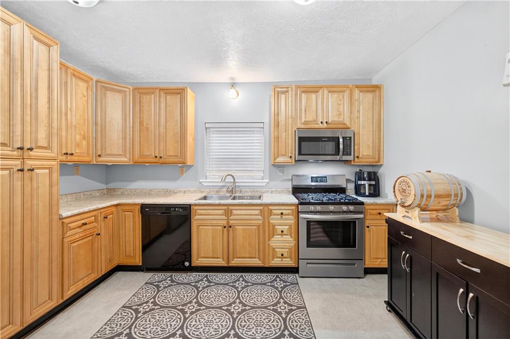 1 6th Avenue Freedom, PA 15042 - Photo 4 of 20 a kitchen with granite countertop a stove top oven sink and cabinets