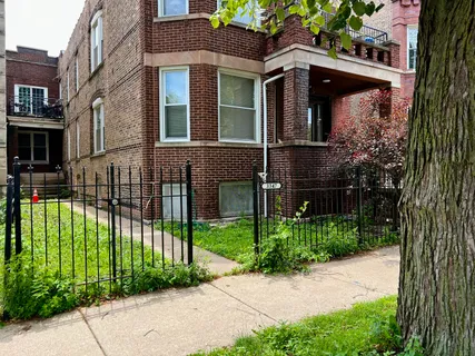 a view of a brick house with a yard and plants
