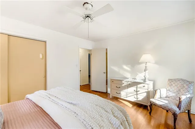 a bedroom with a bed chandelier and a window