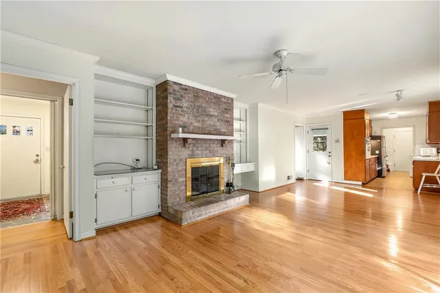 a view of a livingroom with wooden floor a fireplace and window