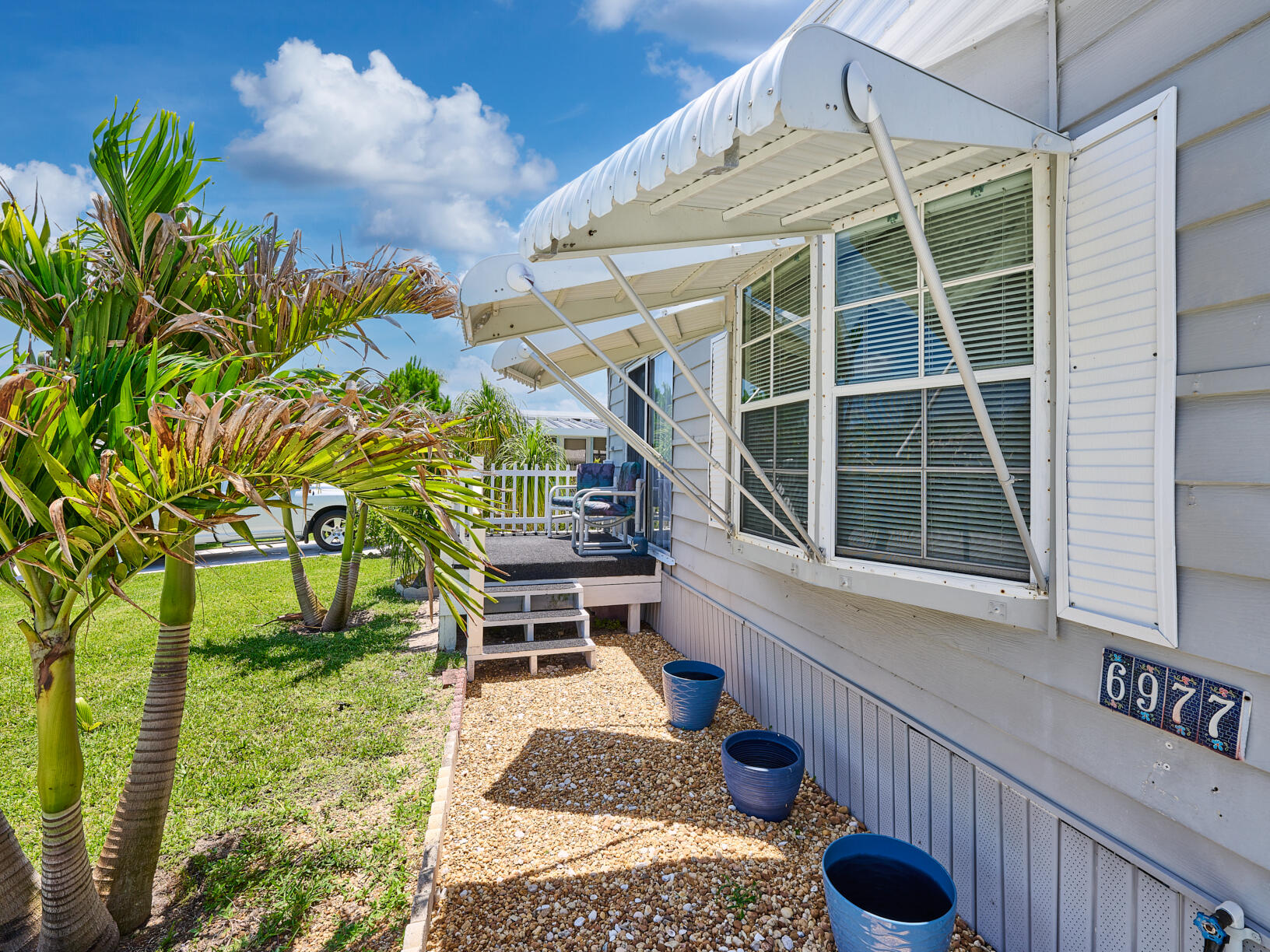 6977 Southeast Delegate Street Hobe Sound, FL 33455 - Photo 7 of 60 a house view with a sitting space and garden space