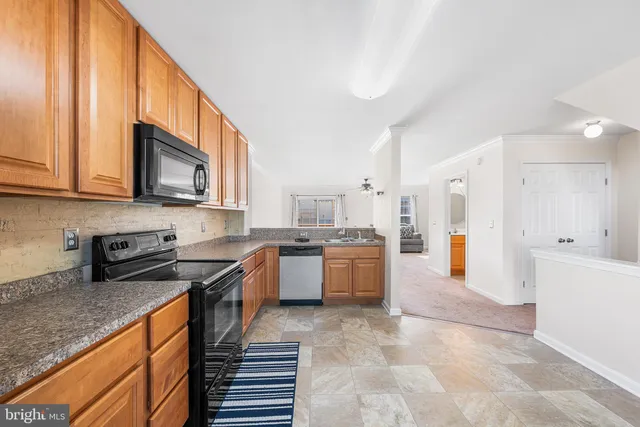 a large kitchen with stainless steel appliances granite countertop a stove a sink dishwasher and a refrigerator