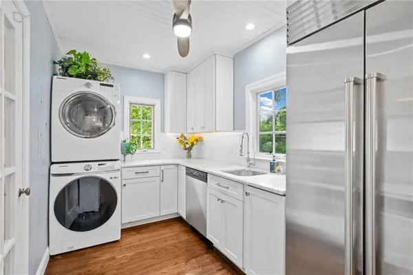 a kitchen with kitchen island a sink cabinets and a washer dryer