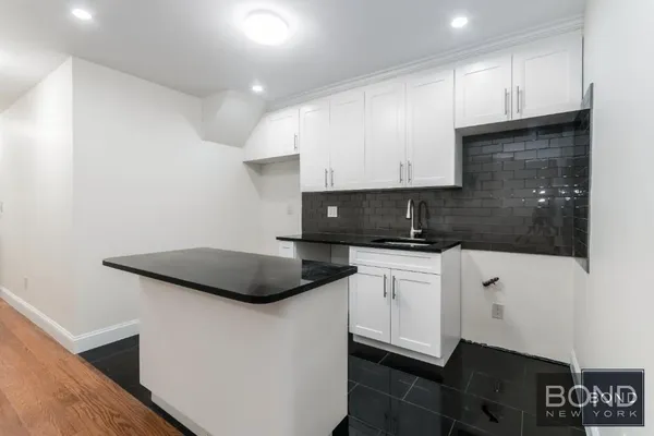 a kitchen with stainless steel appliances granite countertop a sink a stove a microwave and cabinets