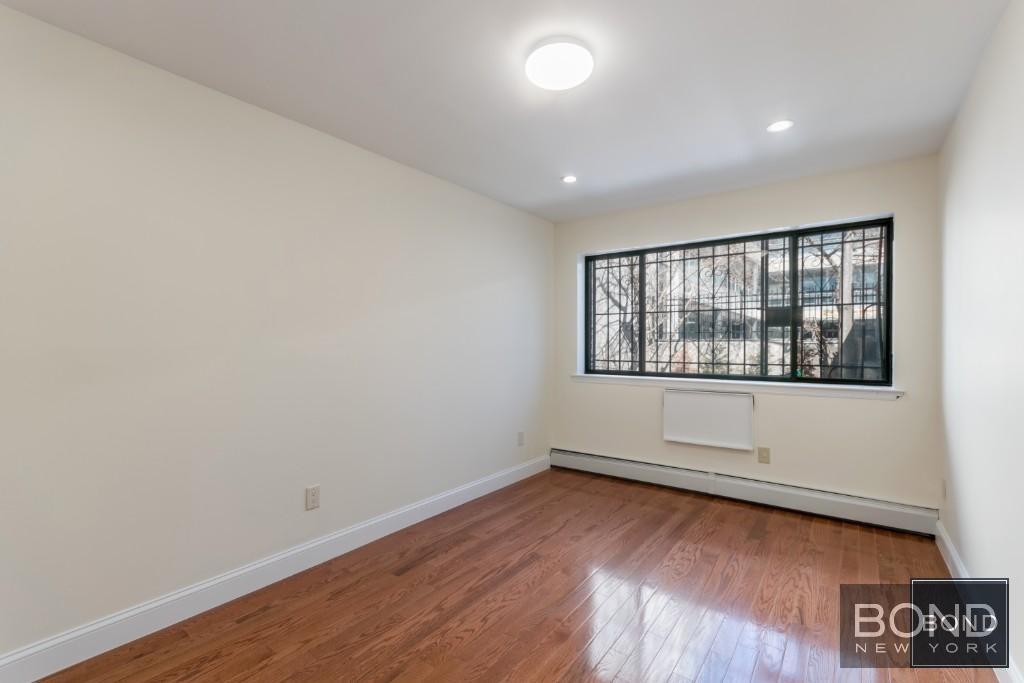 29-23 23rd Road, Unit 1 Queens, NY 11105 - Photo 4 of 6 wooden floor in an empty room with a window