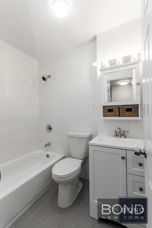29-23 23rd Road, Unit 1 Queens, NY 11105 - Photo 6 of 6 a bathroom with a toilet a sink and bathtub