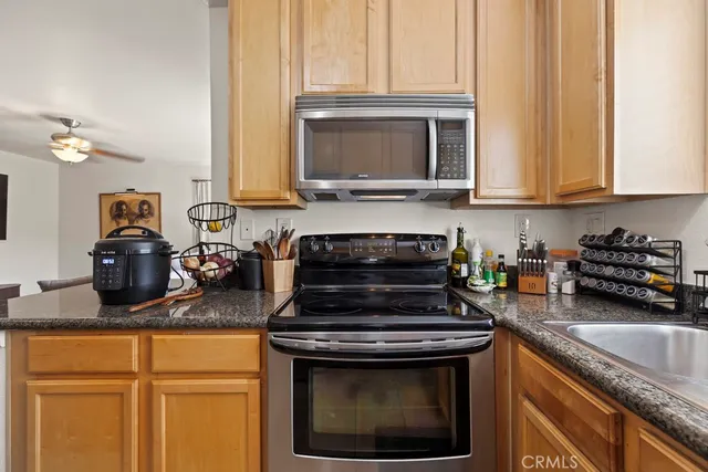 a kitchen with granite countertop a stove a sink and a microwave