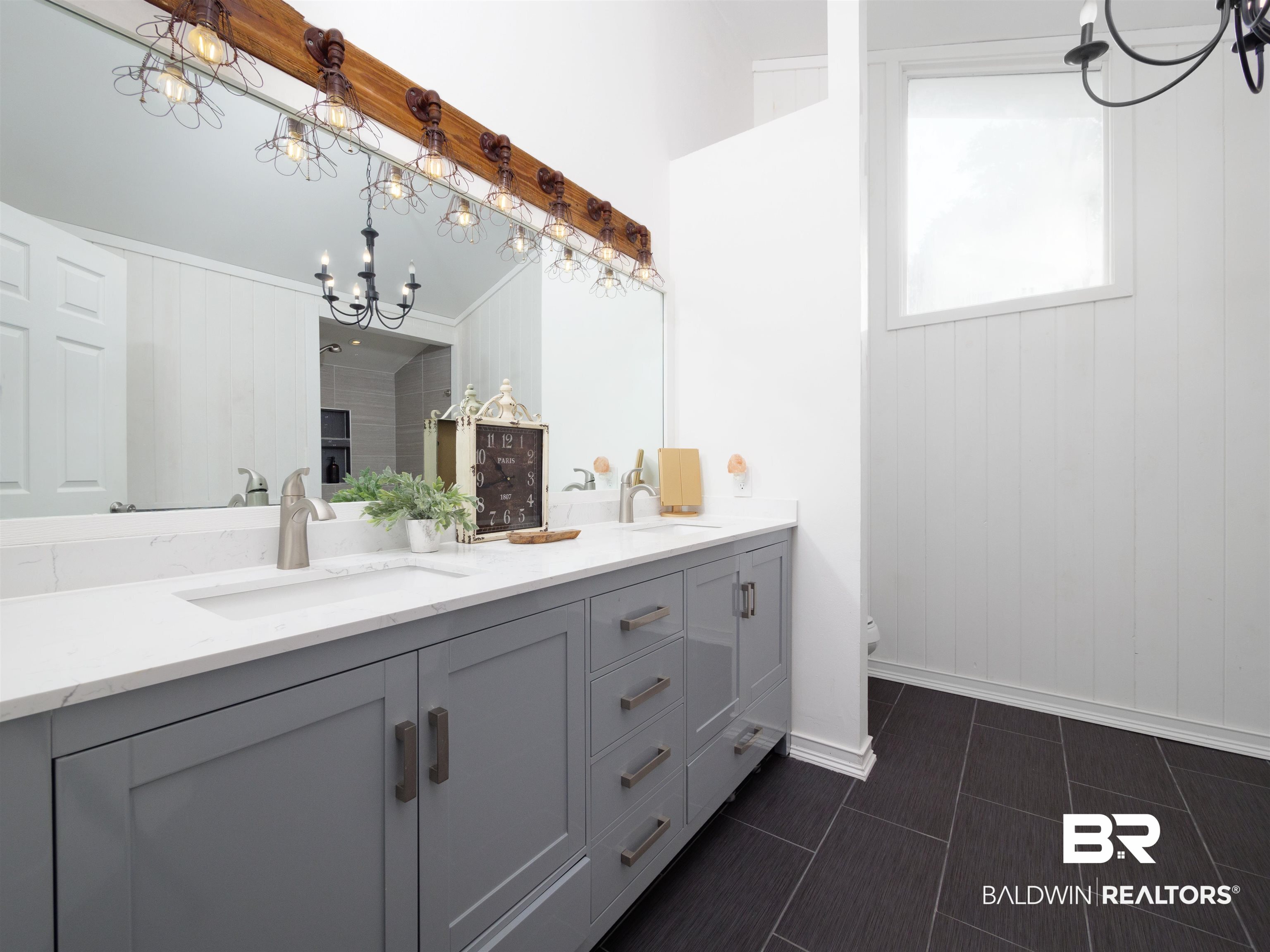 494 Ridgewood Drive Daphne, AL 36526 - Photo 27 of 40 Bathroom with wood walls, toilet, vanity, ornamental molding, and a chandelier