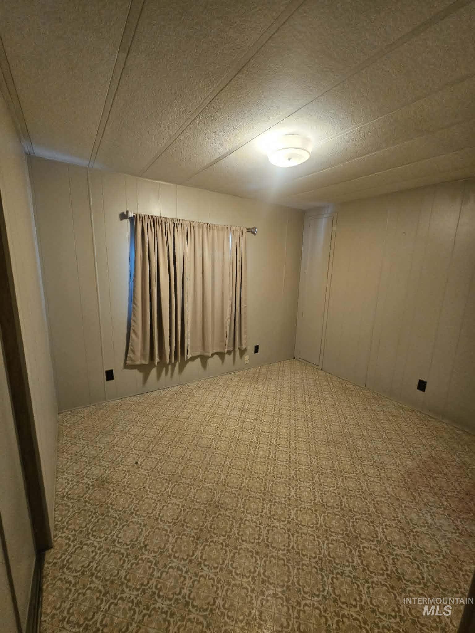 461 Greenleaf Street Boise, ID 83713 - Photo 6 of 19 Neutral tone wall paneling with a patterned floor covering and a centered ceiling light fixture
