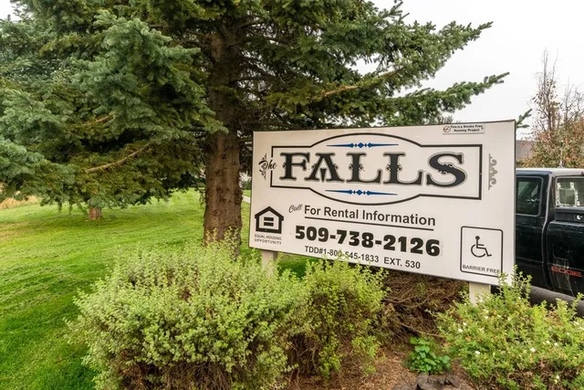 a sign broad in front of the red tree