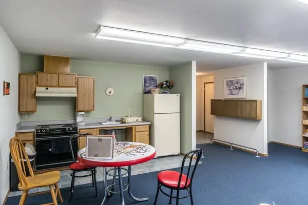 a kitchen with a dining table chairs and a refrigerator