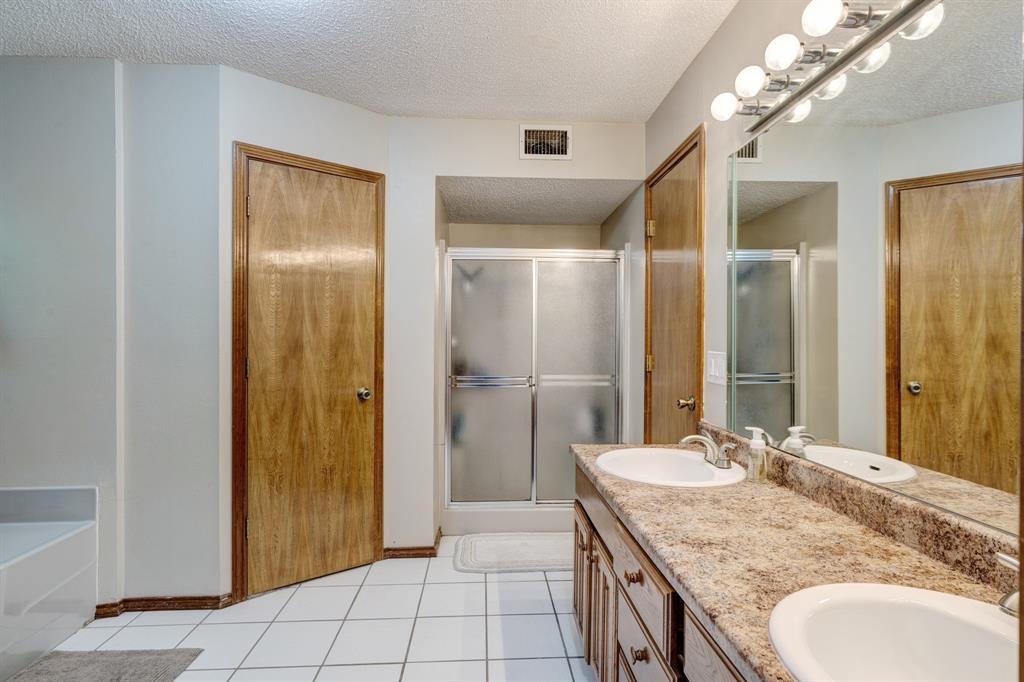 730 Cedar Creek Drive Reno, TX 75462 - Photo 12 of 28 a bathroom with a granite countertop sink a mirror and a shower