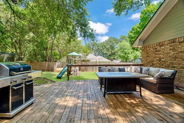 a view of a deck with chairs a barbeque with wooden floor and fence