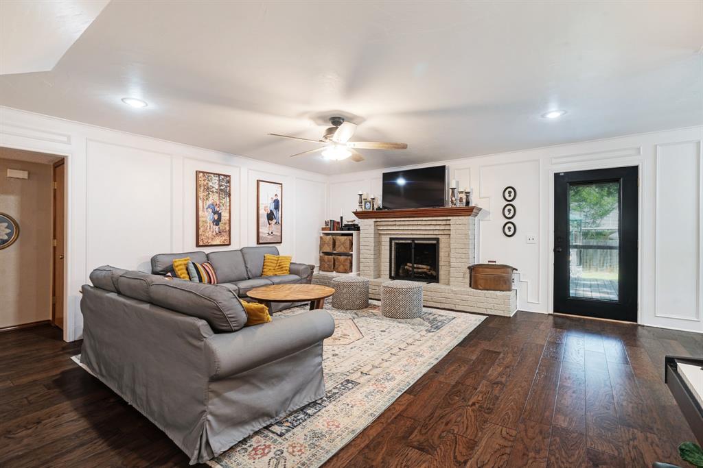 730 Cedar Creek Drive Reno, TX 75462 - Photo 5 of 28 a living room with furniture a fireplace a flat screen tv and wooden floor