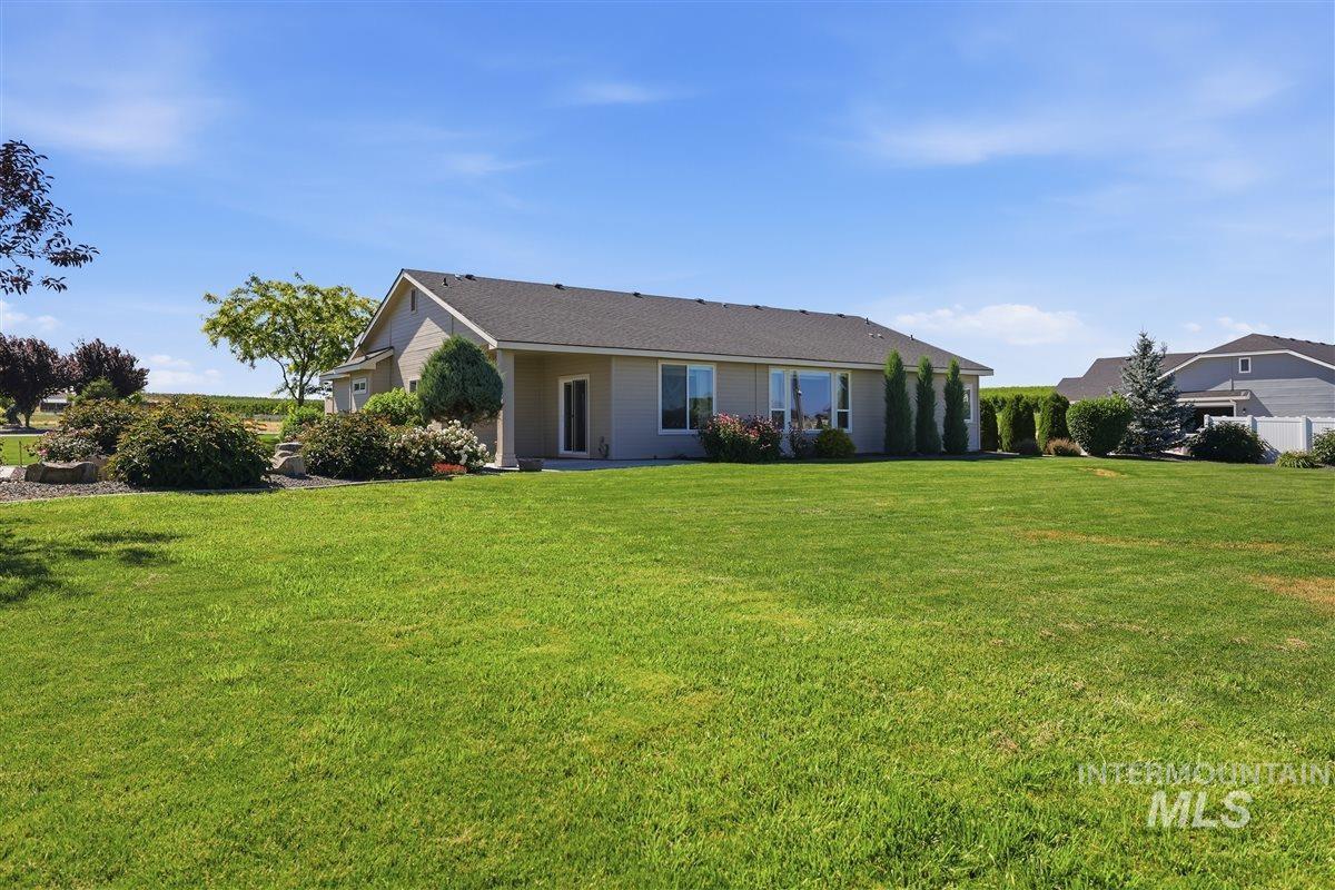 13496 Hockberger Ranch Road Caldwell, ID 83607 - Photo 33 of 40 Spacious exterior featuring a light-colored stucco finish, a dark asphalt shingle roof, and multiple large windows