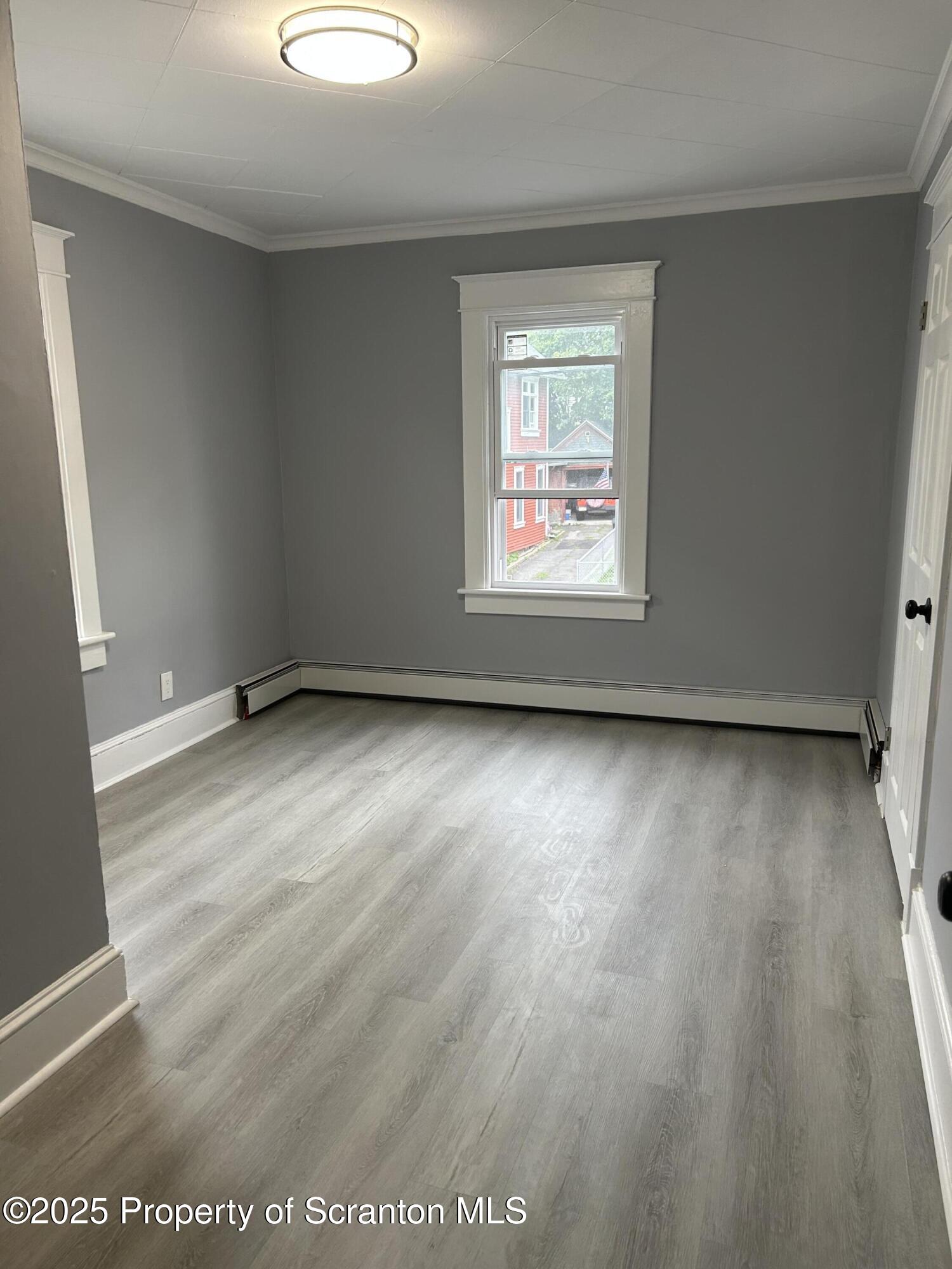 99 Washington Street Carbondale, PA 18407 - Photo 14 of 20 an empty room with wooden floor and windows