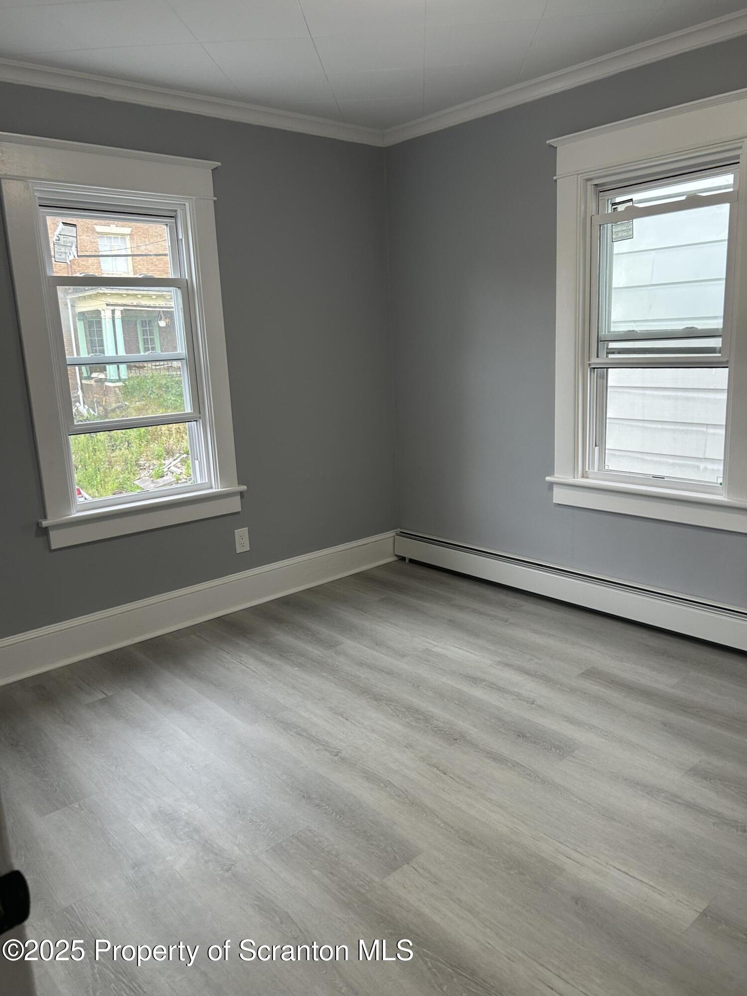 99 Washington Street Carbondale, PA 18407 - Photo 16 of 20 a view of an empty room with wooden floor and a window