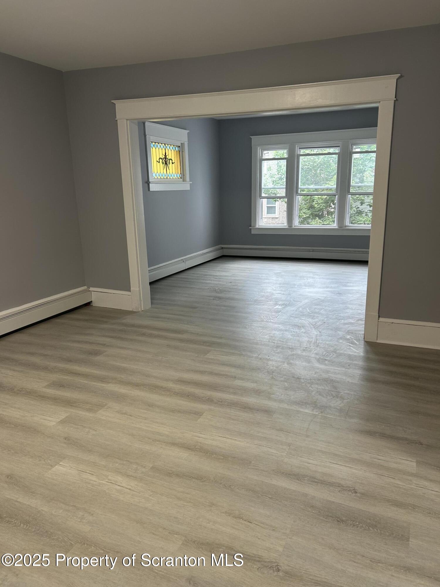 99 Washington Street Carbondale, PA 18407 - Photo 9 of 20 a view of an empty room with window and wooden floor
