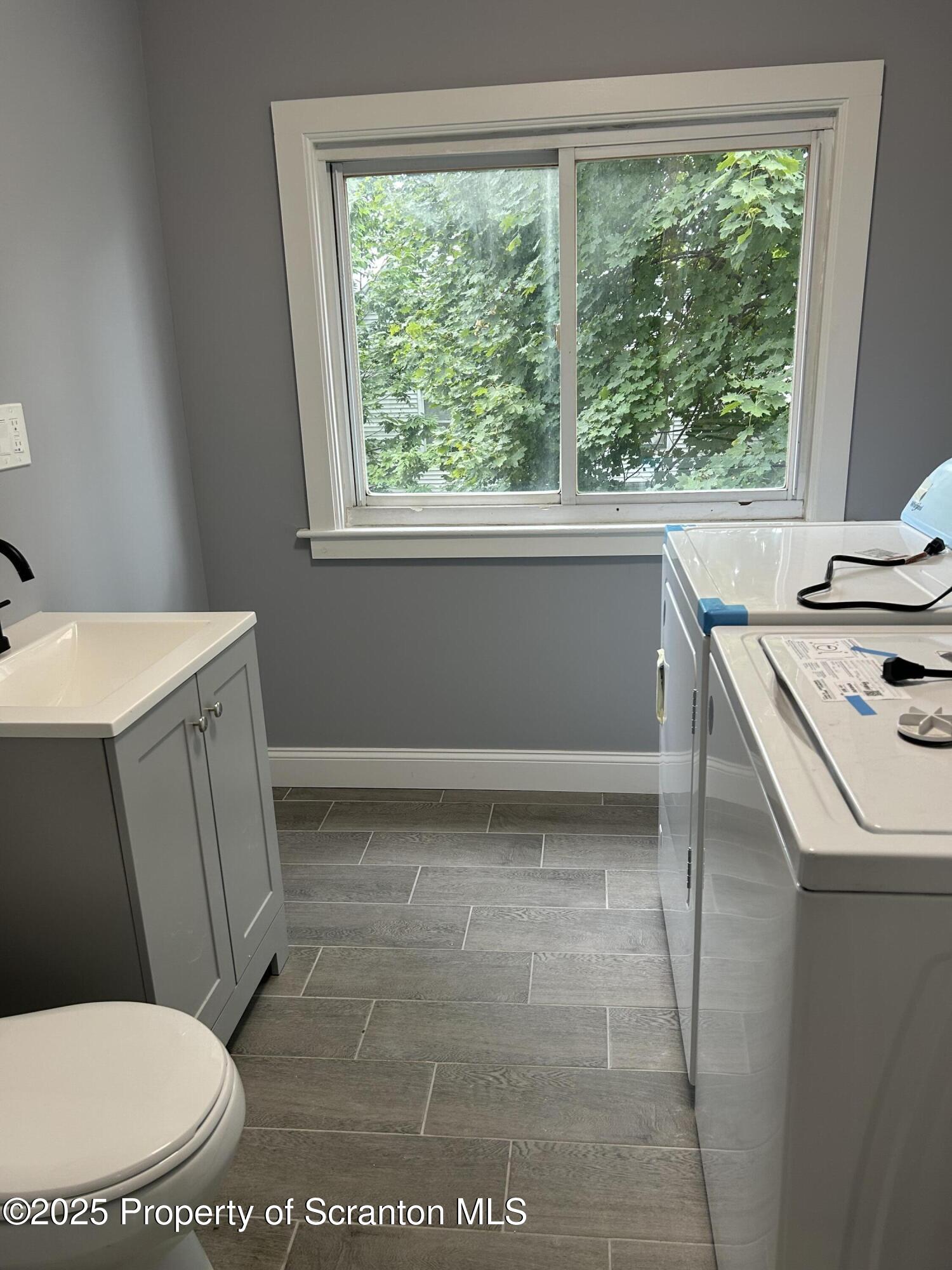 99 Washington Street Carbondale, PA 18407 - Photo 10 of 20 a bathroom with a sink toilet and window