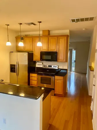 a kitchen with stainless steel appliances granite countertop a sink a stove and a wooden floors