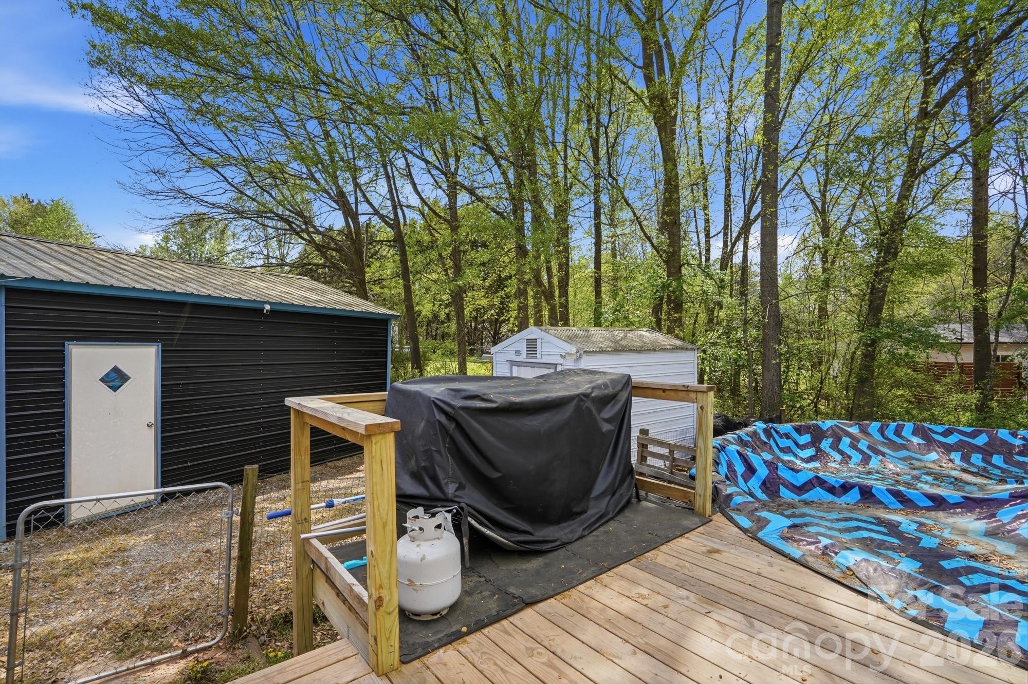 605 Ridgewood Court Mount Holly, NC 28120 - Photo 24 of 32 a view of a patio with table and chairs a barbeque with wooden fence and floor