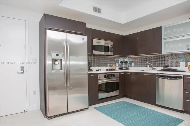 a kitchen with stainless steel appliances granite countertop a refrigerator and a sink