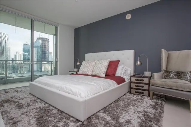 a bedroom with a bed and large window