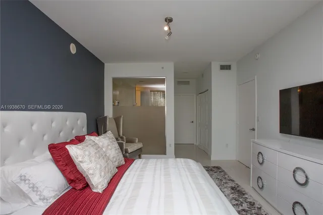 a bedroom with a bed and a flat screen tv