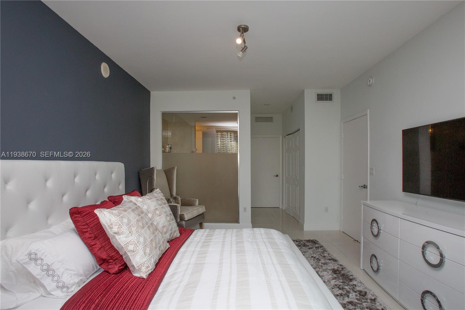 90 Southwest 3rd Street, Unit 2402 Miami, FL 33130 - Photo 19 of 28 a bedroom with a bed and a flat screen tv