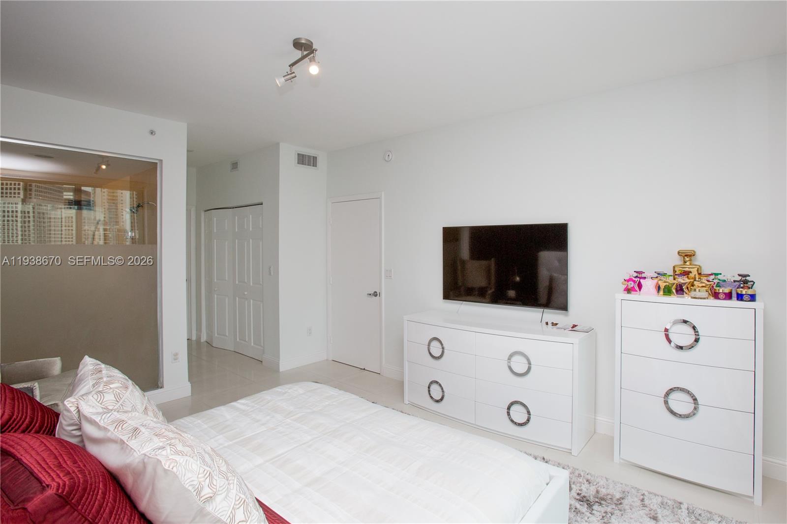 90 Southwest 3rd Street, Unit 2402 Miami, FL 33130 - Photo 21 of 28 a bedroom with a flat screen tv on the dresser and a flat screen tv