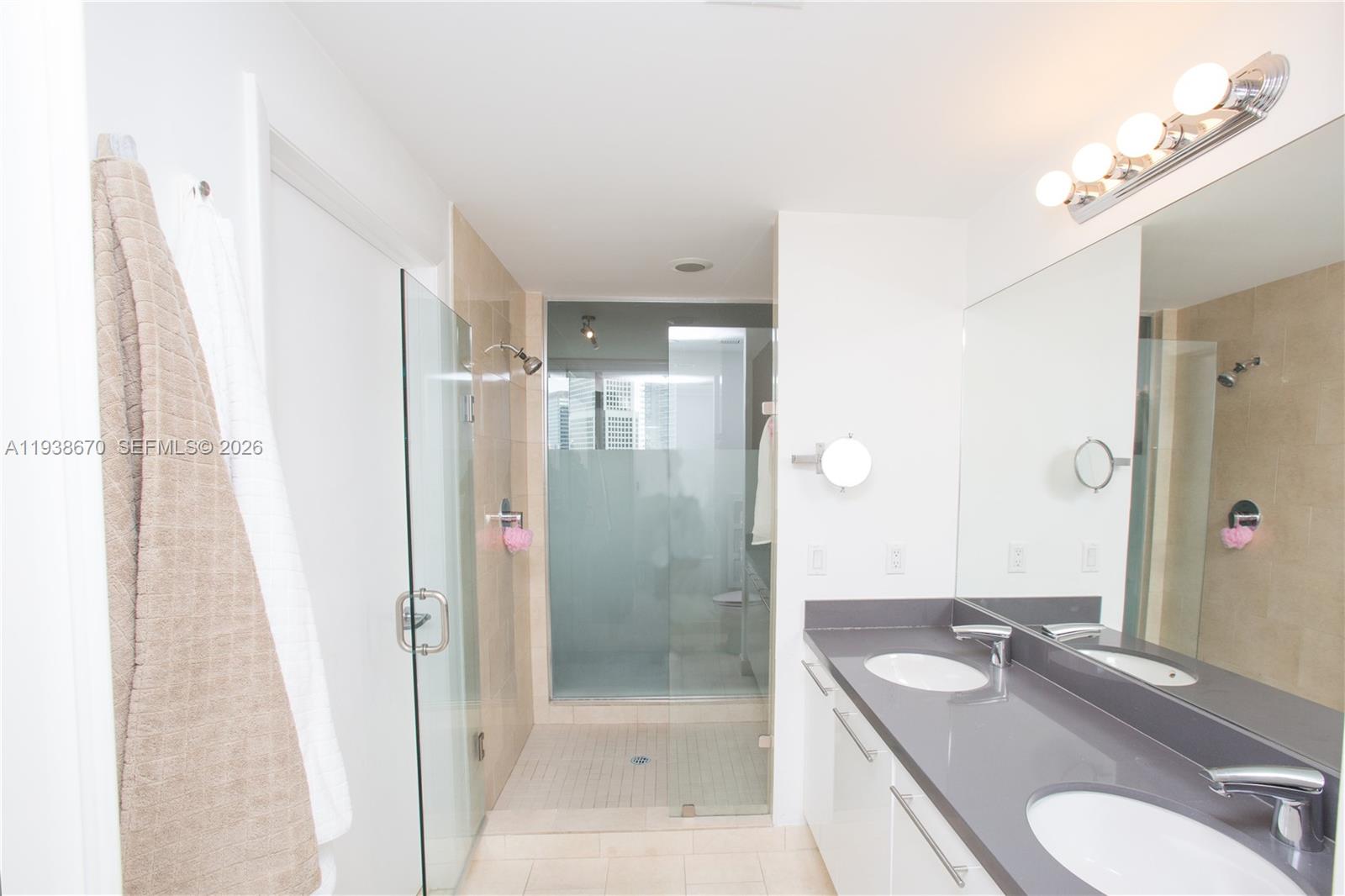 90 Southwest 3rd Street, Unit 2402 Miami, FL 33130 - Photo 5 of 28 a bathroom with a granite countertop sink toilet and shower