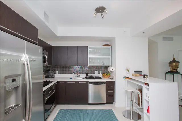a kitchen with a sink a refrigerator and cabinets