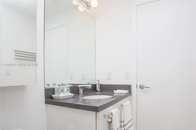 a bathroom with a granite countertop sink and a mirror