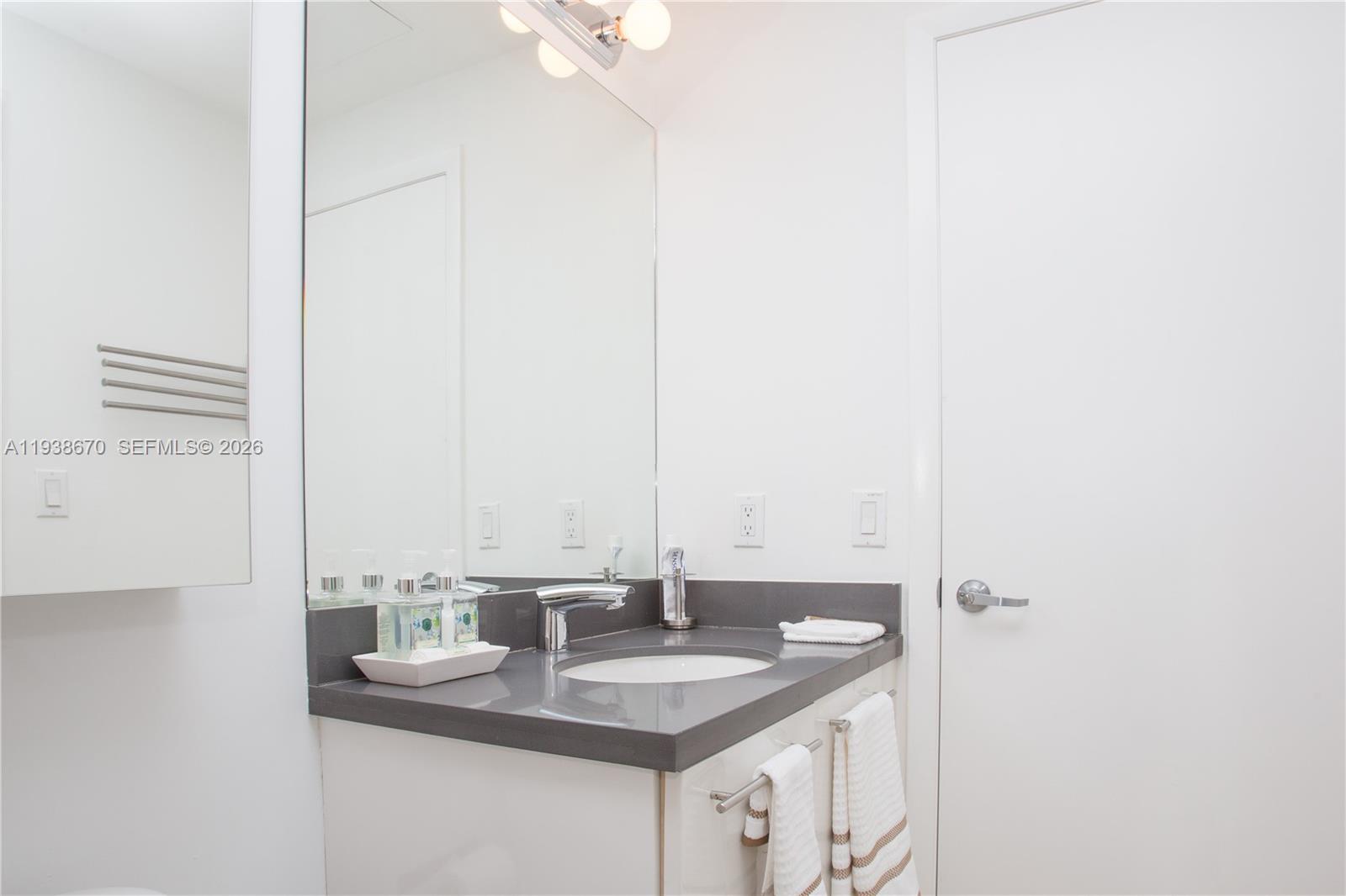 90 Southwest 3rd Street, Unit 2402 Miami, FL 33130 - Photo 9 of 28 a bathroom with a granite countertop sink and a mirror