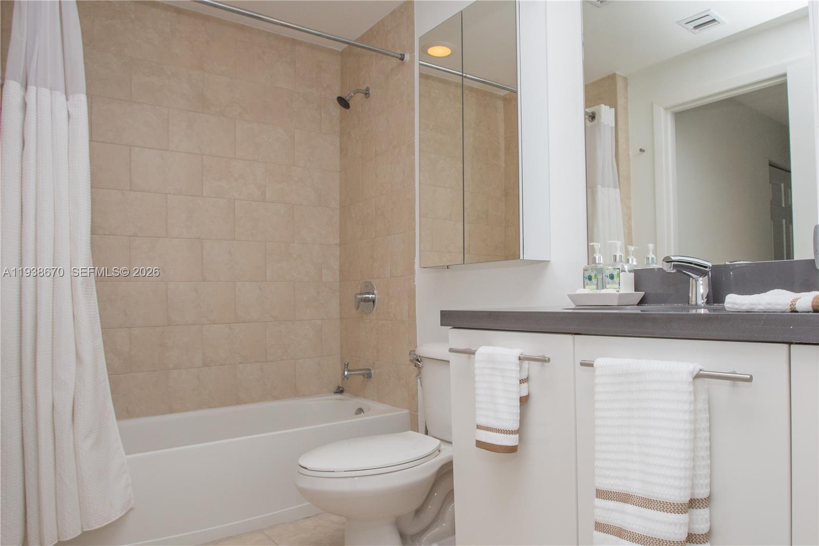 90 Southwest 3rd Street, Unit 2402 Miami, FL 33130 - Photo 10 of 28 a bathroom with a granite countertop sink a toilet and shower