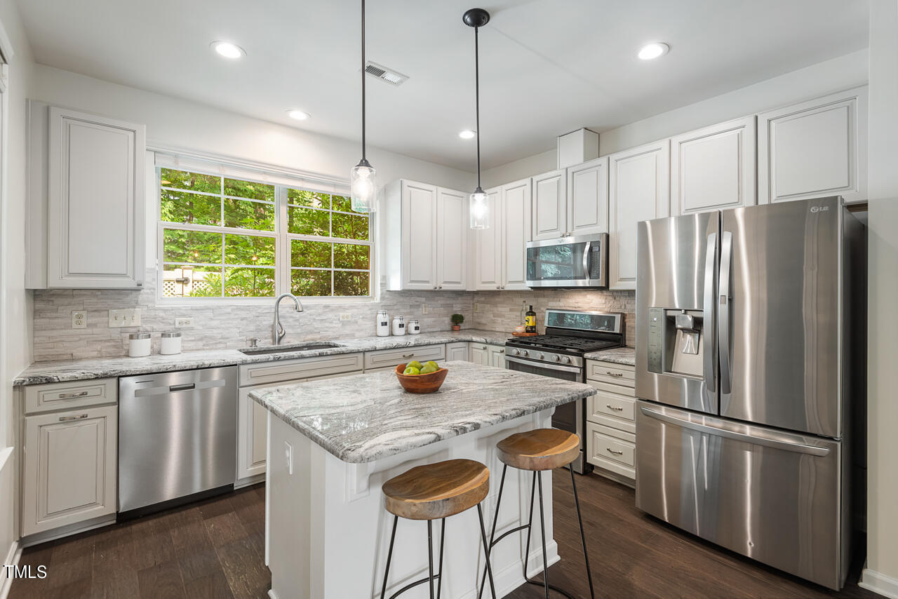 26 Intuition Circle Durham, NC 27705 - Photo 11 of 42 a kitchen with stainless steel appliances granite countertop a stove a refrigerator a sink and a microwave
