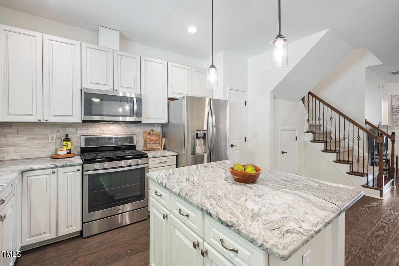 26 Intuition Circle Durham, NC 27705 - Photo 12 of 42 a kitchen with stainless steel appliances granite countertop a sink a stove and a wooden floors