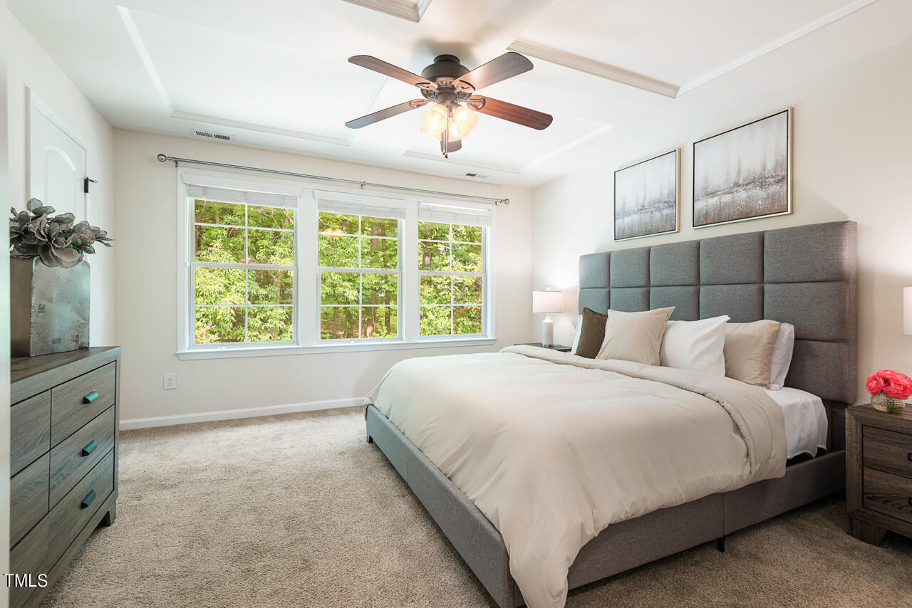 26 Intuition Circle Durham, NC 27705 - Photo 21 of 42 a bedroom with a large bed and a chandelier fan