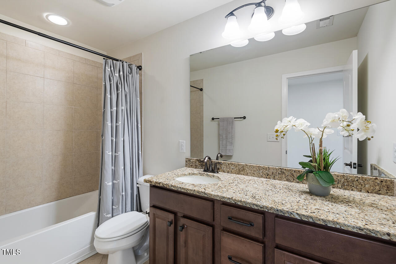 26 Intuition Circle Durham, NC 27705 - Photo 32 of 42 a bathroom with a granite countertop sink a toilet and a mirror