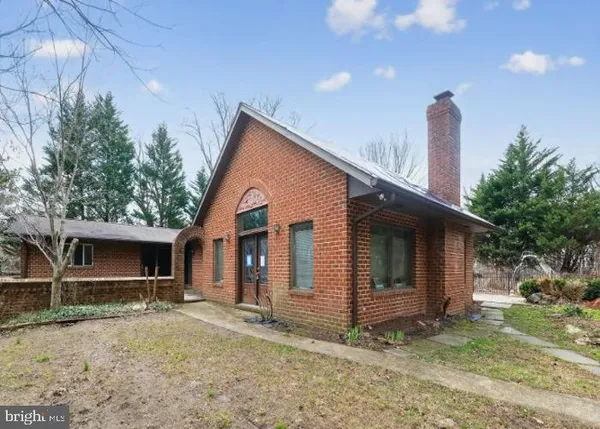 a view of a house with backyard and trees
