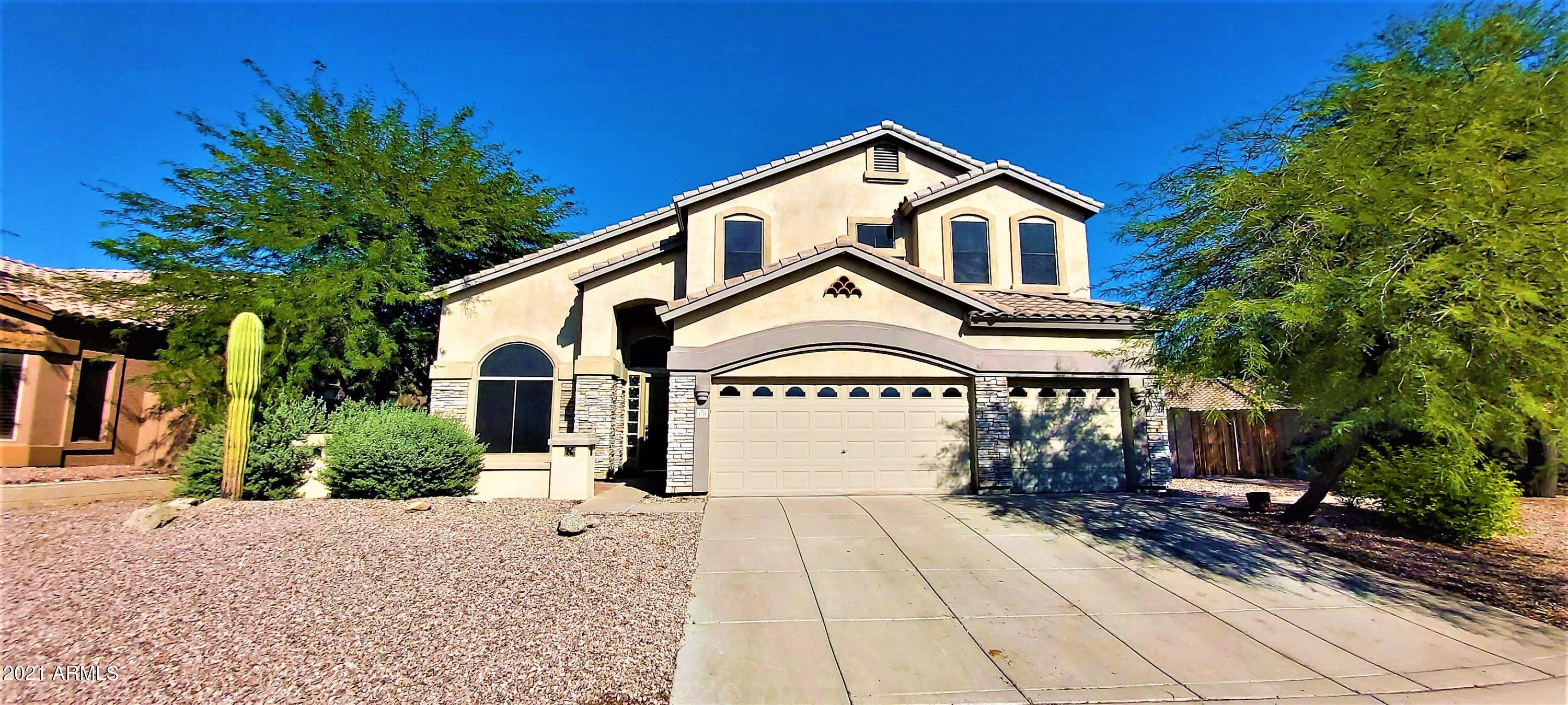 a view of a white house with a clock on the side of a road