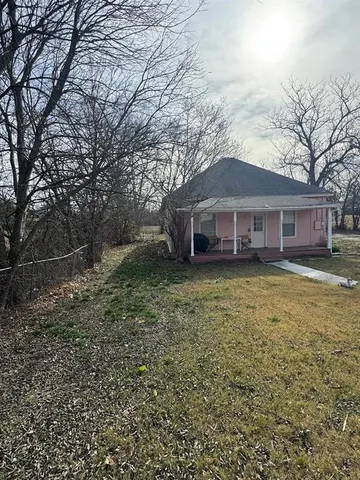 a front view of a house with a garden and trees